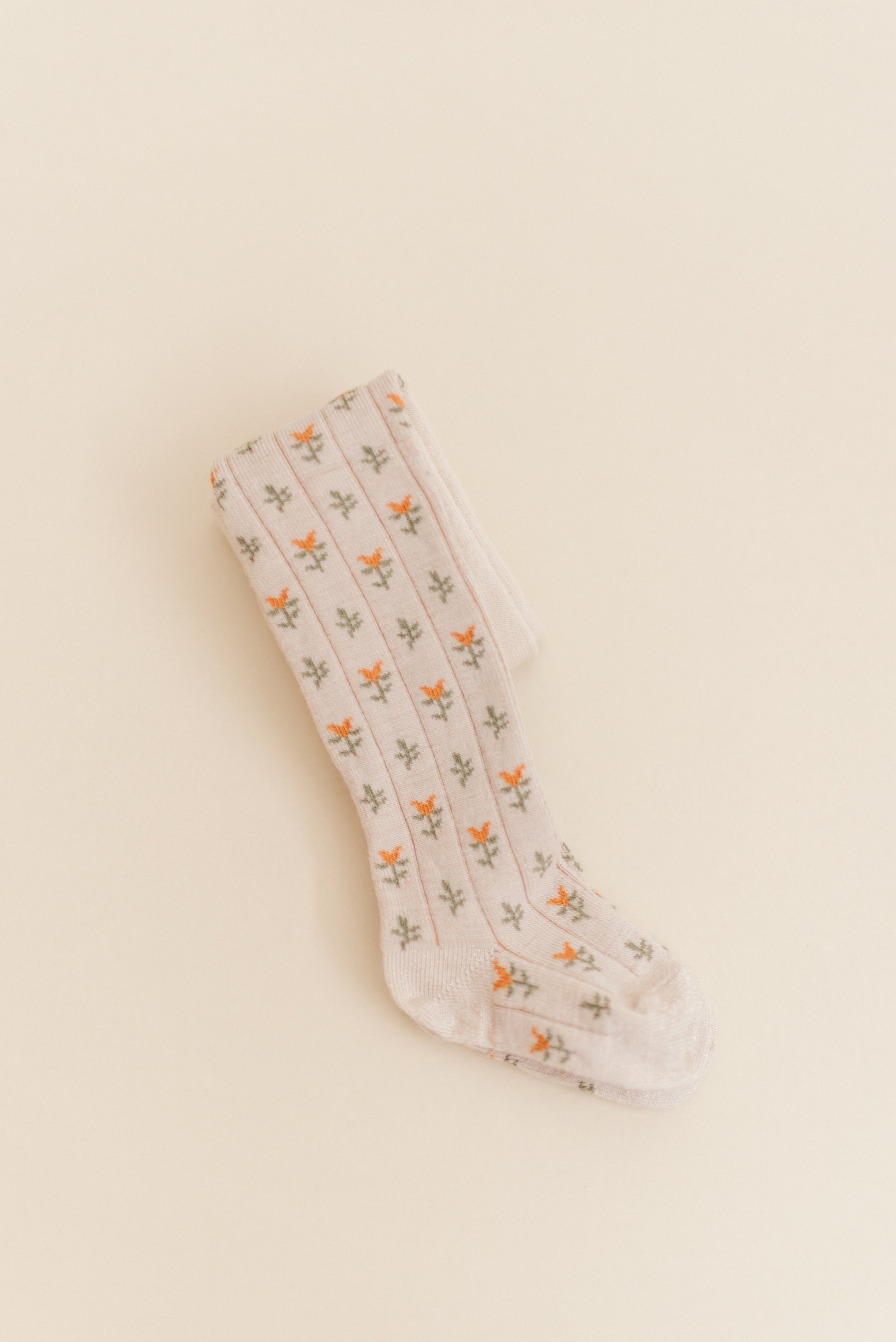Kennedy Spice Tight from Shop Little Millers — soft oatmeal-base children’s tights with delicate spice-colored floral tulip pattern, stretch knit for a comfortable fit, designed in Arizona with OEKO-TEX® certified fabric safe for sensitive skin.