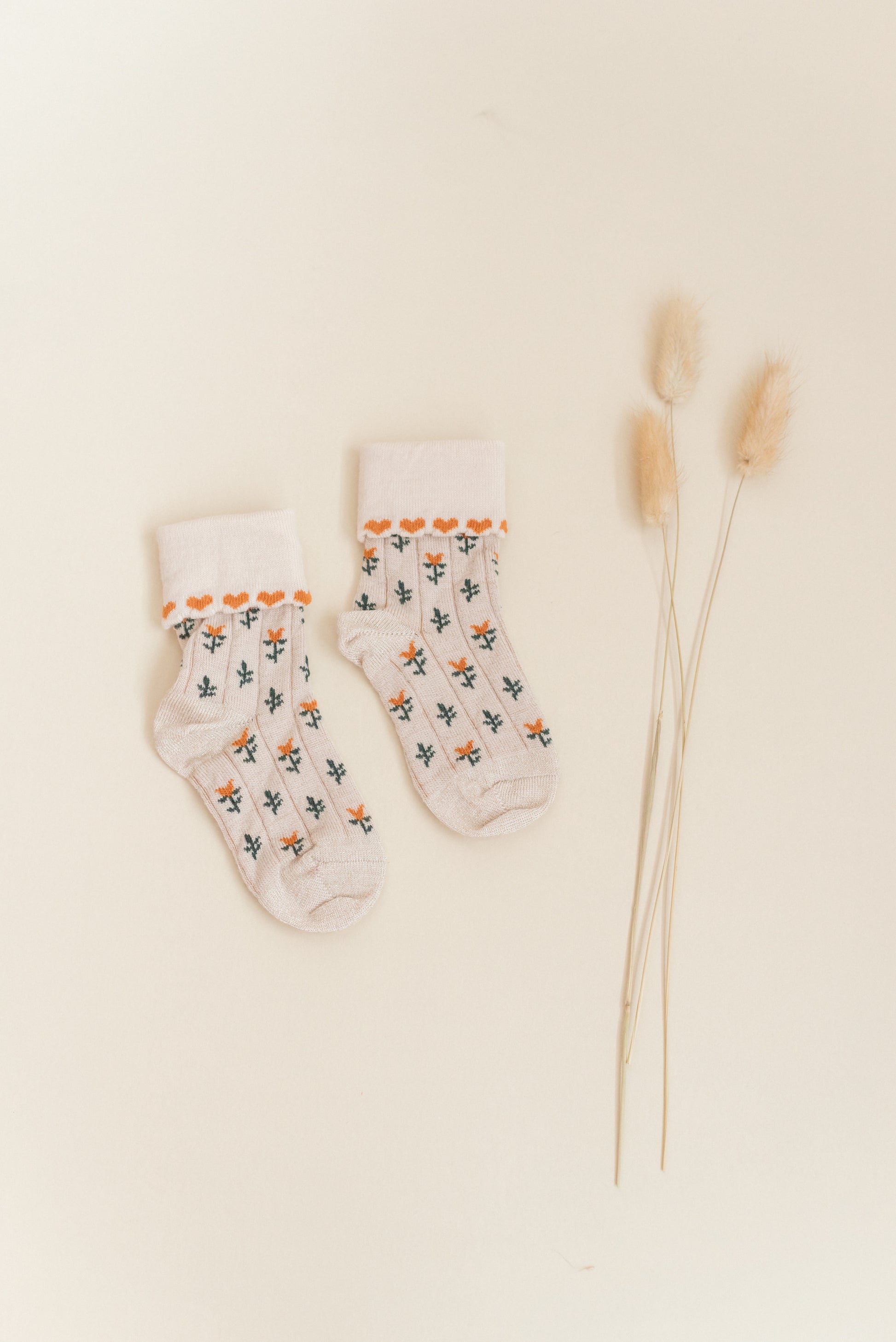 Kennedy children’s socks from Shop Little Millers, featuring a soft cream knit base with delicate floral detailing and subtle heart-inspired trim, designed for babies and kids with a snug yet stretchy fit for all-day comfort, everyday wear, and special outfits.