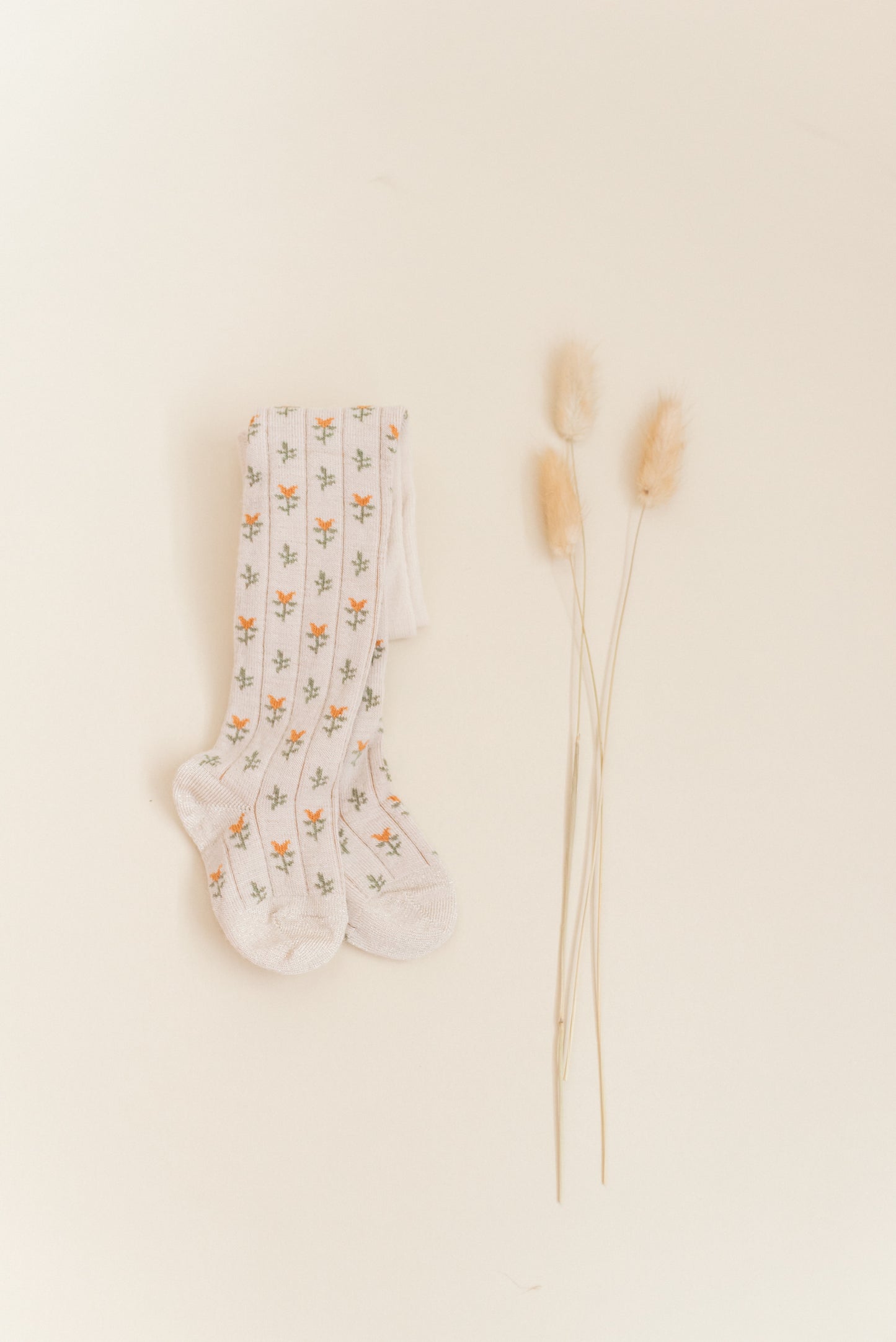 Kennedy Spice Tight from Shop Little Millers — soft oatmeal-base children’s tights with delicate spice-colored floral tulip pattern, stretch knit for a comfortable fit, designed in Arizona with OEKO-TEX® certified fabric safe for sensitive skin.
